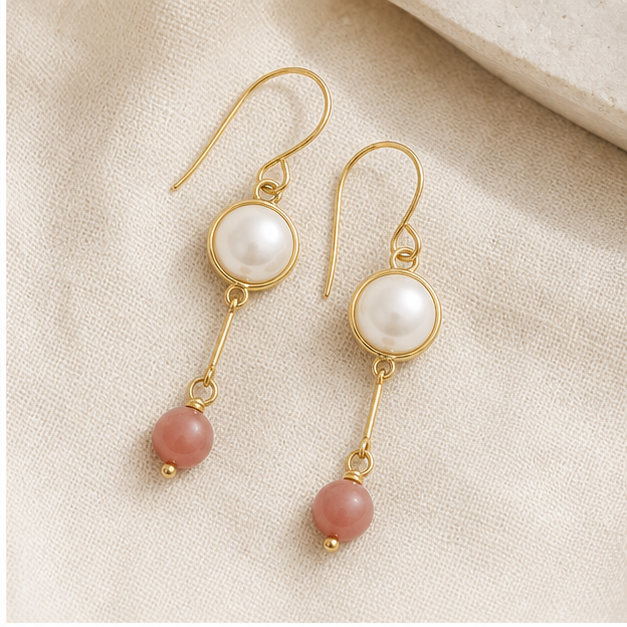 Gold pearl drop earrings photographed on textured linen